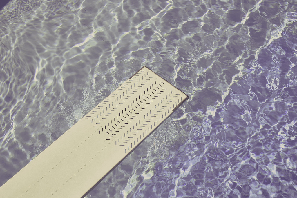 Springboard over rippling pool water